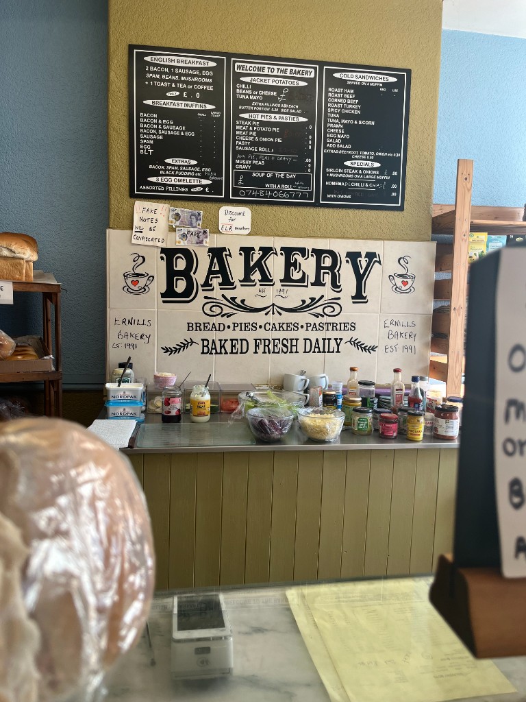 The Bakery Cafe counter with menu boards for hot pies, cold sandwiches and daily specials